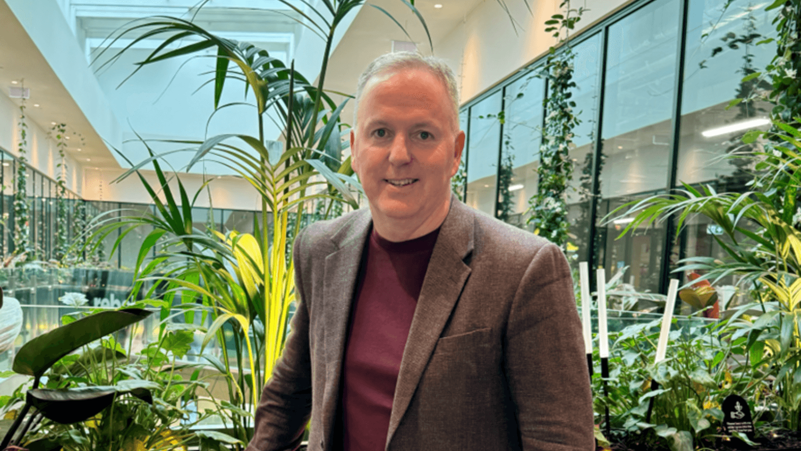Shane Cavell standing in front of indoor plants in an atrium