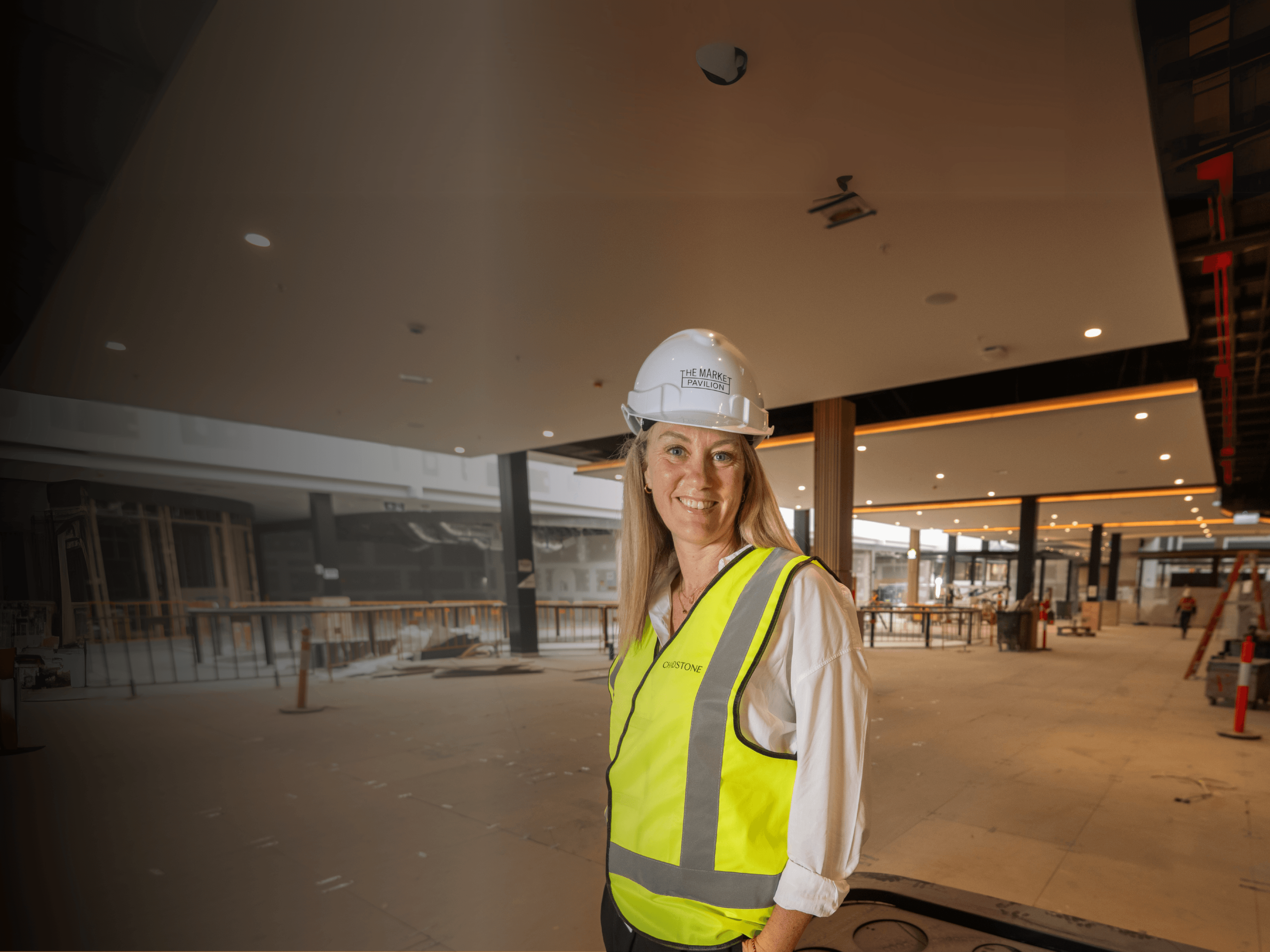 Renee Blome stands in a development site with a high vis vest and hard hat