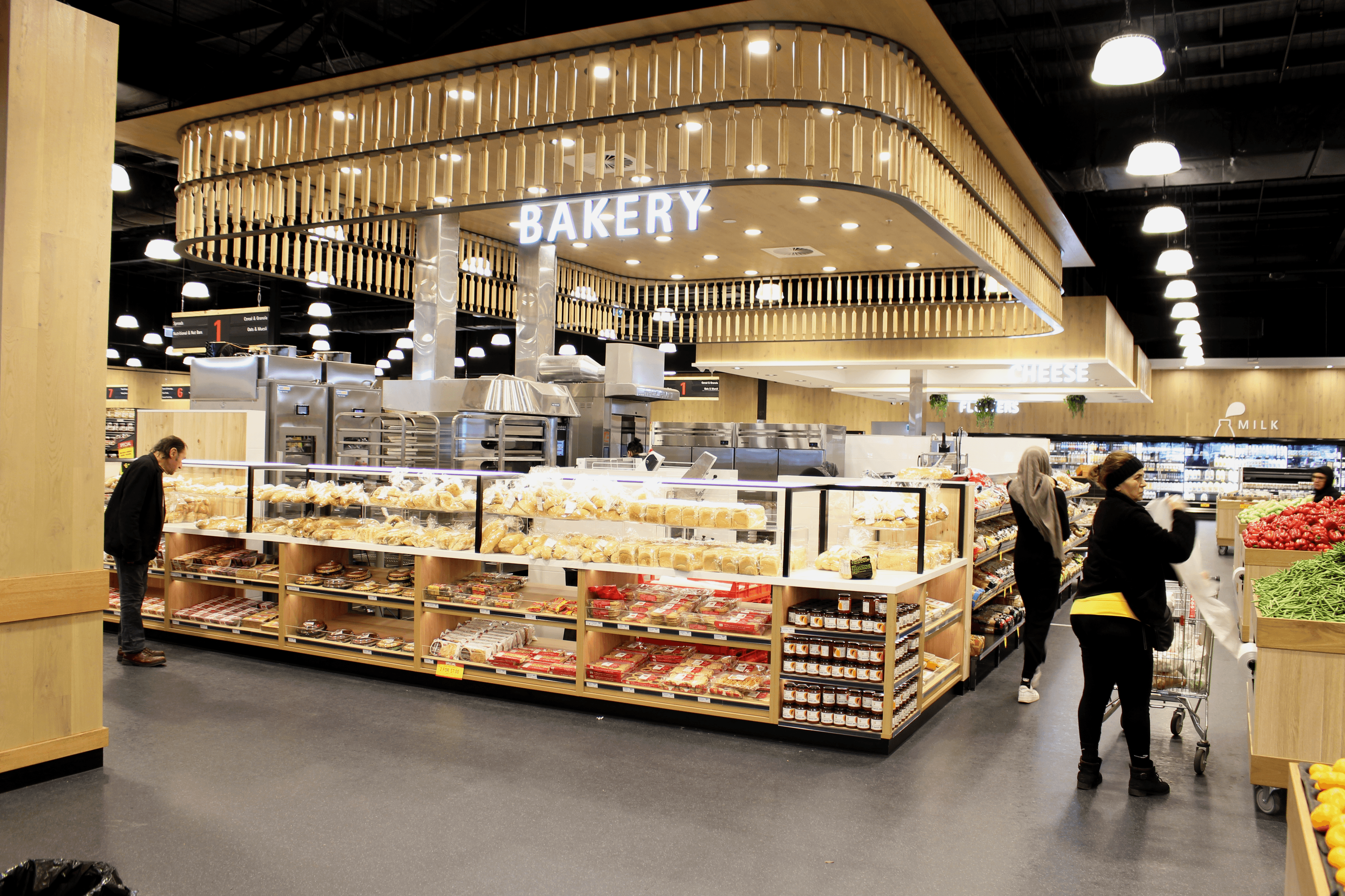 People shopping at an indoor bakery and grocers