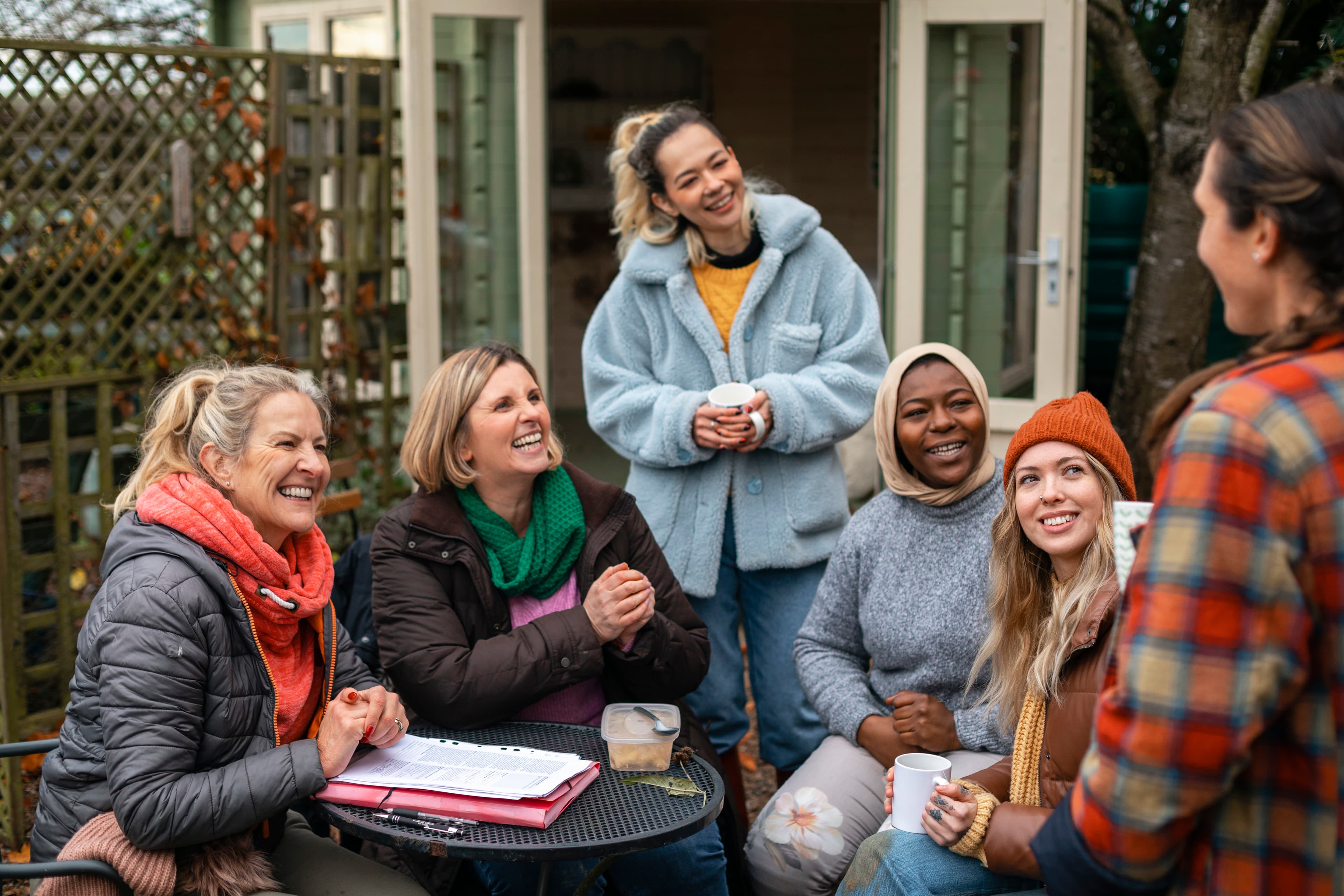 A group of people sat at a small table talking