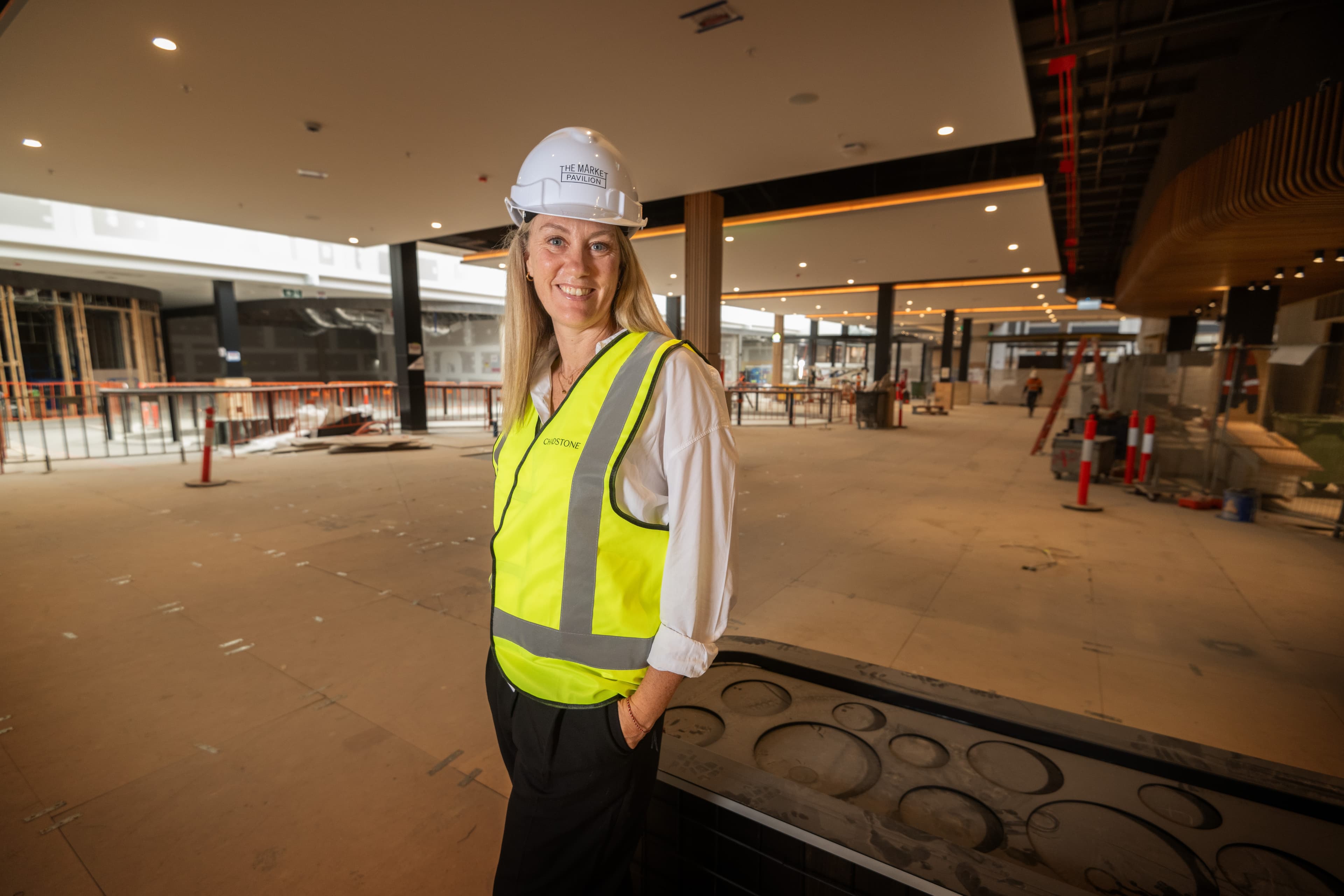 Renee Blome stands in a development site with a high vis vest and hard hat